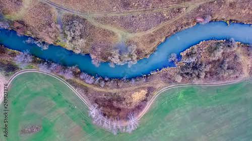 Top view of the bend of the river in a colorful autumn field photo