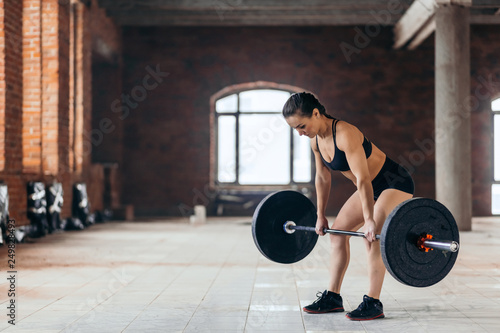 professional female athlete training with weight. weightlifting. powerlifting . side view full length photo. copy space
