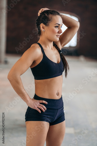 beautiful slim awesome muscular young athlete standing indoors. close up side view photo