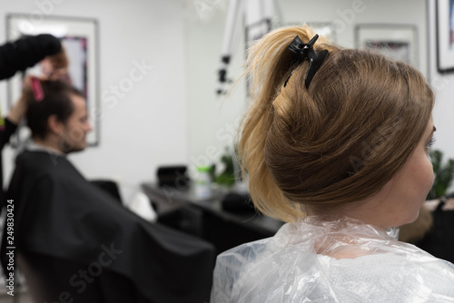 Client sitting in the chair in front of the mirror in beauty salon, waiting for the procedures