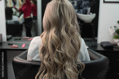 Beautiful hairstyle of woman after dying hair and making highlights in hair salon