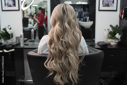 Beautiful hairstyle of woman after dying hair and making highlights in hair salon