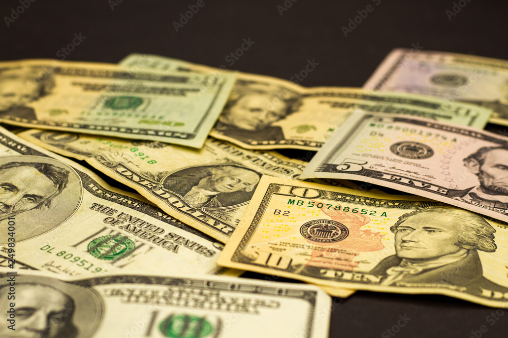 Easy money dollar bills on a dark background. Crumpled US dollars lie on a dark table. The concept of easy money. Easy money dollar bills on a dark background. Crumpled US dollars lie on a dark table. The concept of easy money.