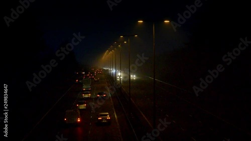 Timelapse Of Traffic On Motorway From Dark Through Sunrise To day On Foggy Morning photo