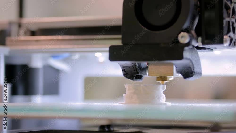 Close up shot - 3D printer prints physical 3D model with plastic wire filament at modern technology exhibition. Additive technologies, science and futuristic concept Close up shot - 3D printer prints physical 3D model with plastic wire filament at modern technology exhibition. Additive technologies, science and futuristic concept