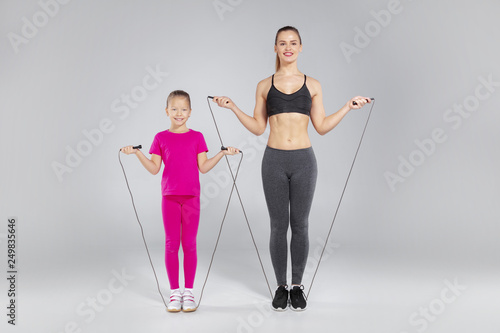 Fotografie Beautiful woman and her daughter with jumping rope