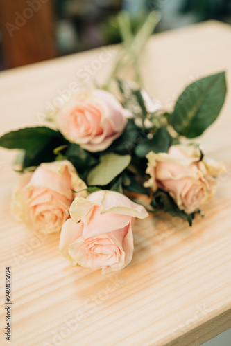 Pink Roses bouquet in a vase on a wooden table. Florist © ManuPadilla