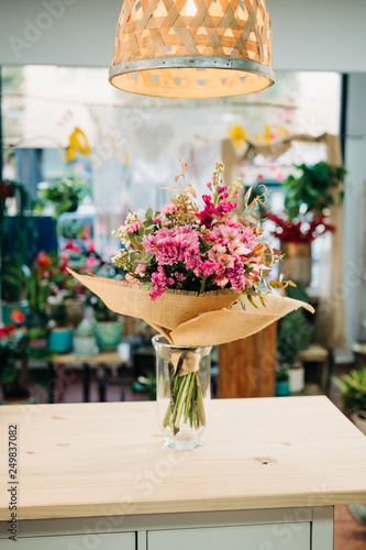 Nice pink and purple flowers bouquet on a wooden table in a florist