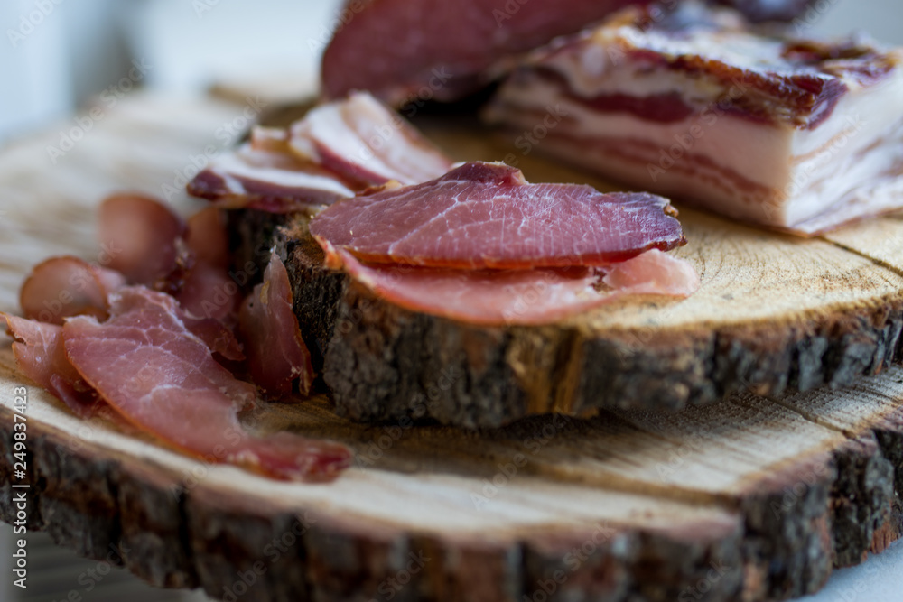 prosciuto slices on wooden chopping board prosciuto slices on wooden chopping board