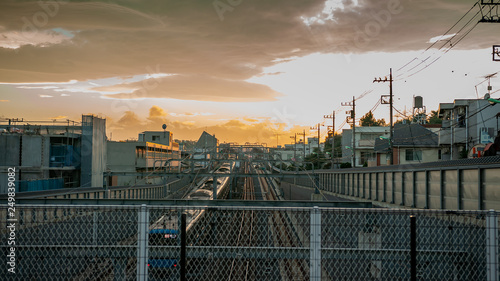 Landscape photo showing the beautiful sunset scene and multiple tracks on a railway in a typical suburban Japanese neighbourhood in the city of Tokyo in Japan.