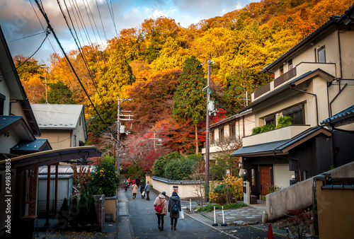 Landscape view of the vibrant and beautiful autumn foliage near the famous Rurikoin Temple, with visitors walking back to the Eizan Electric Railway station. photo