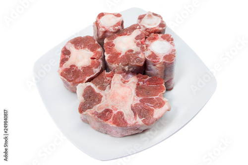 Six pieces of raw rabo de toro or bull's tail isolated on a white square plate on white background
