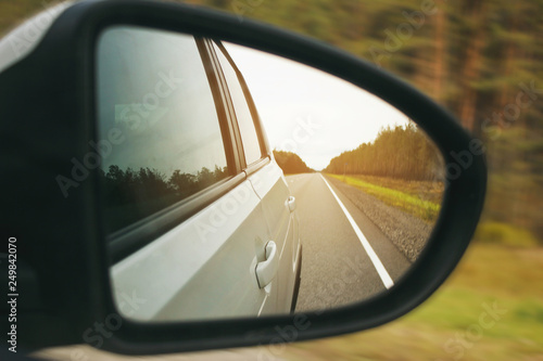 Speed car driving, view from the mirror on an empty highway, motion blur closeup. © bbgreg