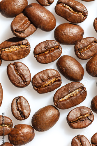Roasted coffee beans on white can be used as background or texture. Close up.