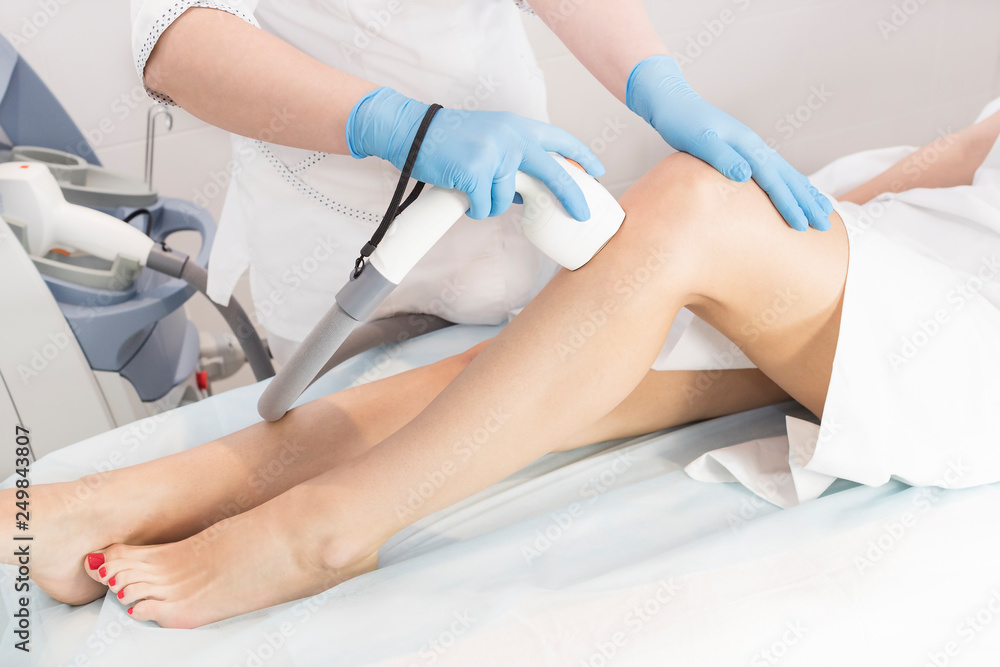 The process of laser depilation of female limbs in the beauty salon. The process of laser depilation of female limbs in the beauty salon.