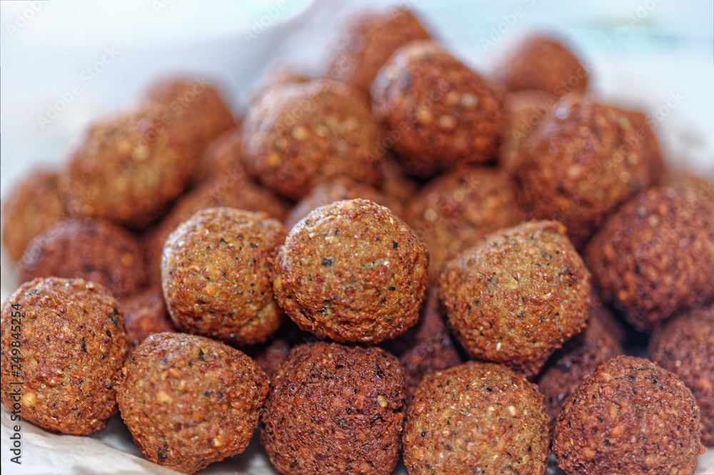 Deep frying falafel. Traditional Mediterranean healthy and vegan food with chickpeas and tahini. Selective focus, shallow depth of field Deep frying falafel. Traditional Mediterranean healthy and vegan food with chickpeas and tahini. Selective focus, shallow depth of field