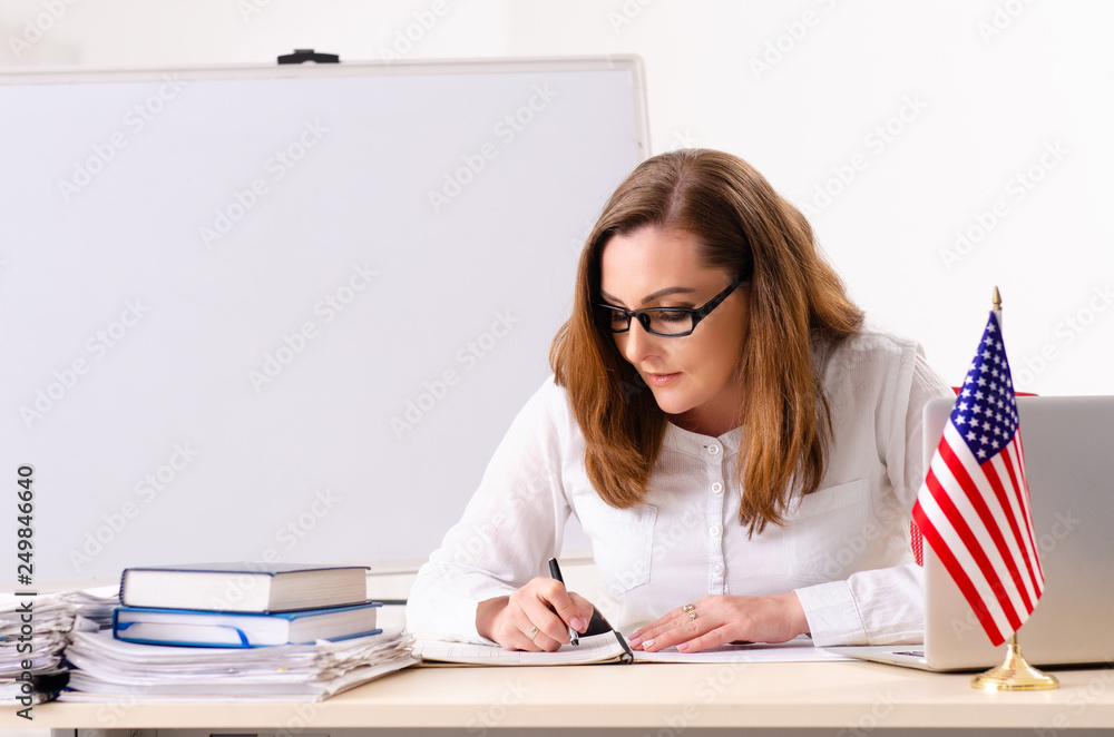 Female english language teacher in front of whiteboard 