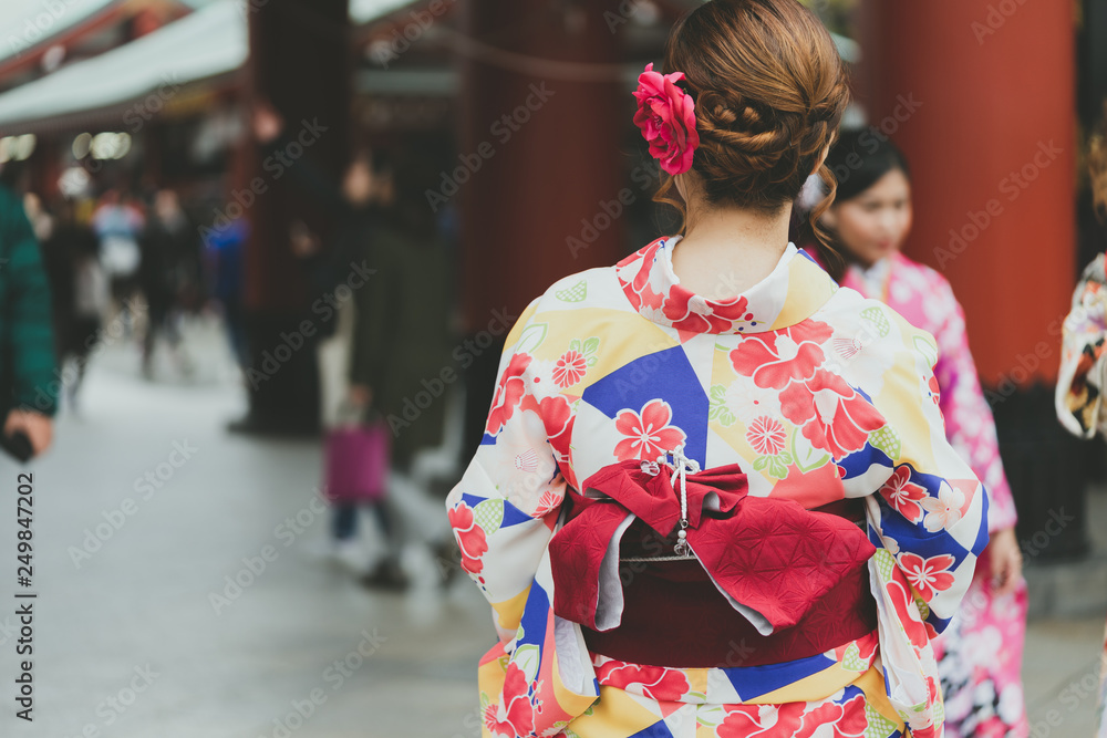 Young girl wearing Japanese kimono standing in front of Sensoji Temple in Tokyo, Japan. Kimono is a Japanese traditional garment. The word Young girl wearing Japanese kimono standing in front of Sensoji Temple in Tokyo, Japan. Kimono is a Japanese traditional garment. The word