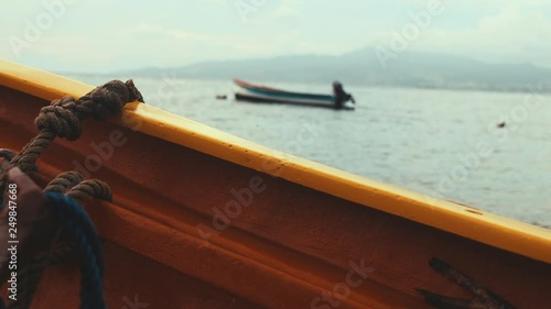 Fisherman tightening a rope on his boat photo