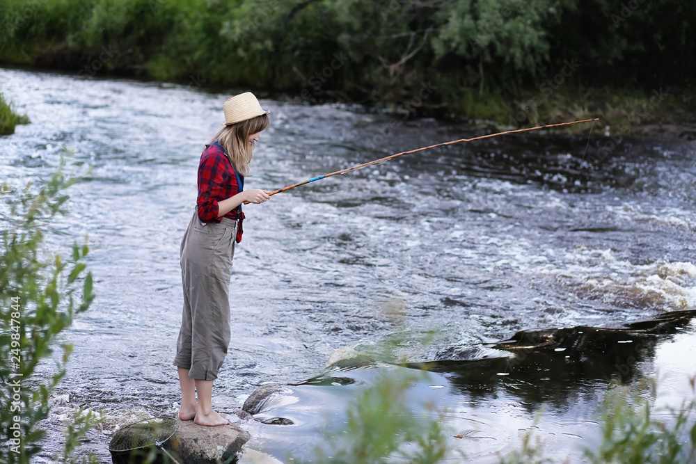 Girl by the river with a fishing rod Girl by the river with a fishing rod