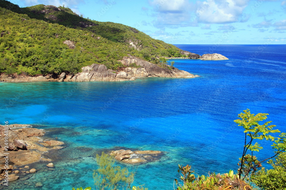 lagoon with clear blue water, tropical greenery and rocks with boulders lagoon with clear blue water, tropical greenery and rocks with boulders