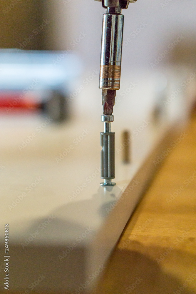Werkzeuge Dübel und Schrauben beim eindrehen in Möbelteile Stock Photo |  Adobe Stock