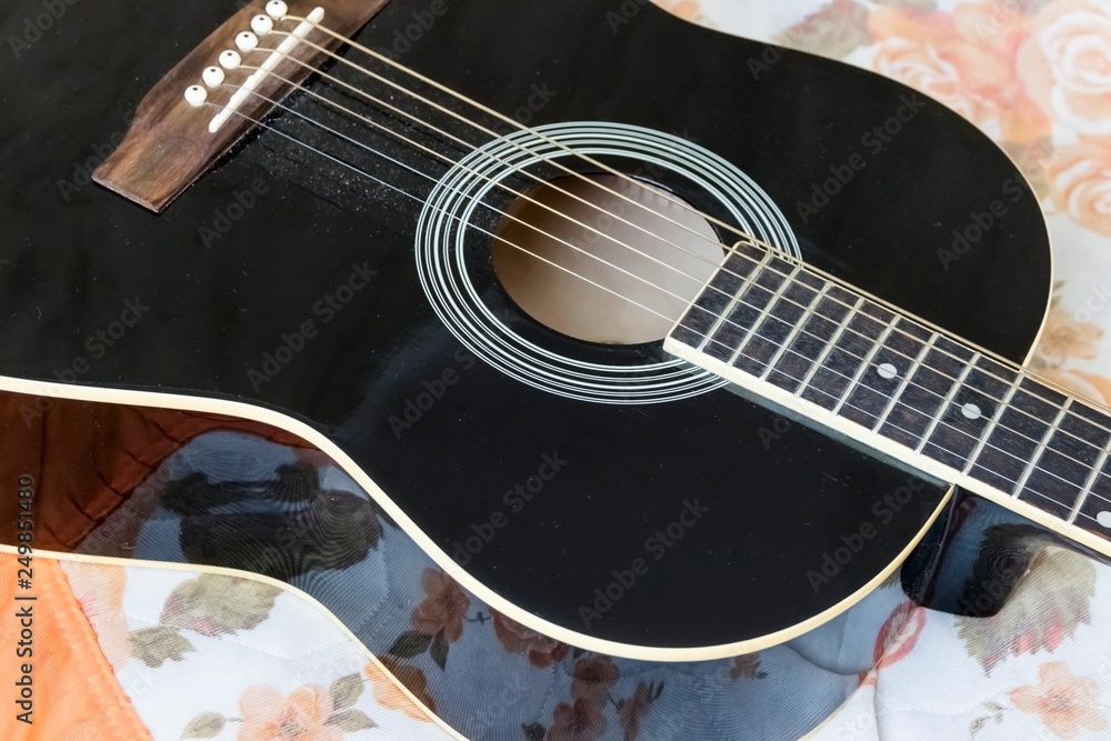 Fototapeta premium Acoustic guitar laying on bed low angle shot from bottom with plectrum on the body