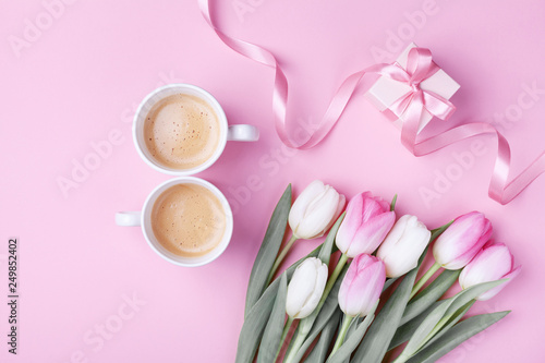 Women day 8 March concept. Morning coffee, gift box and spring tulip flowers on pink pastel background. Flat lay.