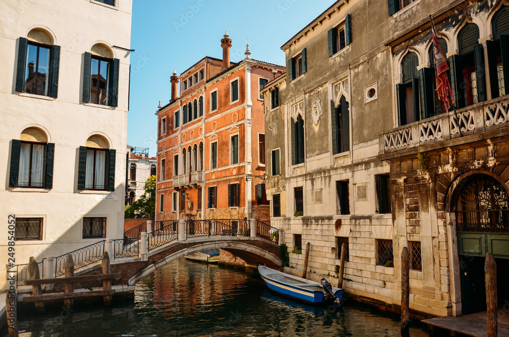 Beautiful venetian street in summer day, Italy. Venice, beautiful romantic italian city on sea with great canal and gondolas, Italy.
