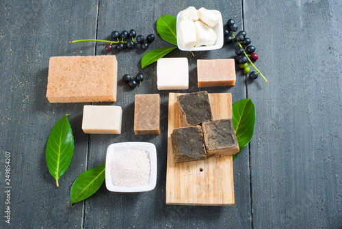 cosmetic clay, soaps, henna blocks, raw shea butter on black wood table