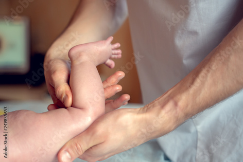 Image of hands of massage therapist making foot massage to small child