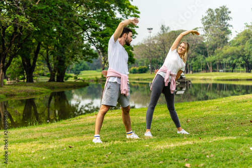 Man and Woman exercise in public garden park in summer