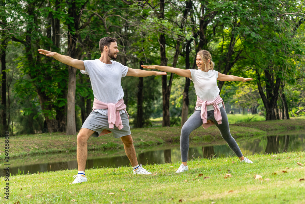 Man and Woman exercise in public garden park in summer Man and Woman exercise in public garden park in summer