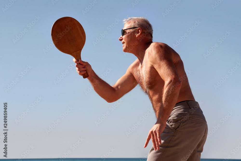 portrait of a man playing beach tennis portrait of a man playing beach tennis