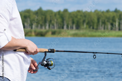 fisherman catches fish on the lake on spinning close-up, background