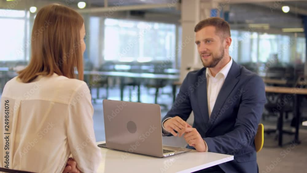 job interview in office. caucasian candid manager talking with unrecognizable woman. successful employer looking with a friendly smile on the aspirant job interview in office. caucasian candid manager talking with unrecognizable woman. successful employer looking with a friendly smile on the aspirant