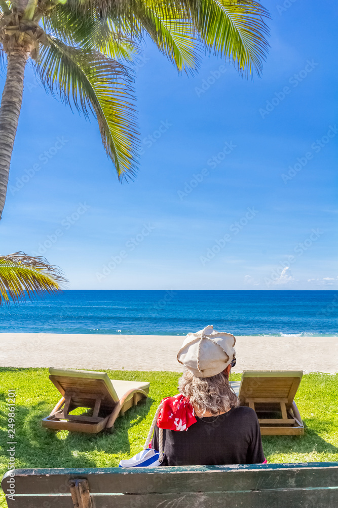 Femme assise face à la mer, plage de Boucan Canot, Réunion 