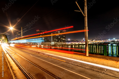 Belgrade, Serbia - February 10, 2019: Belgrade waterfront and Old bridge on the Sava River. Panorama of Belgrade by night with reflection. There are traces of the vehicle on the photo.