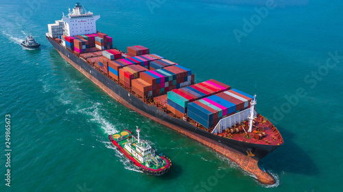 Container ship arriving in port, Tug boat and container ship going to deep sea port, logistic business import export shipping and transportation, Aerial view.