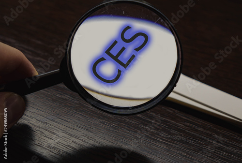Inscription CES enlarged in magnifying glass magnifier.