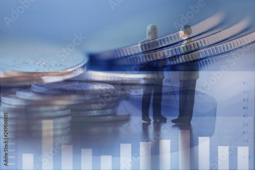 Double exposure row of coins of  Business man and graph,saving,investment and finance concepts. Miniature people Stand in front of a coin,soft focus and blurred style.