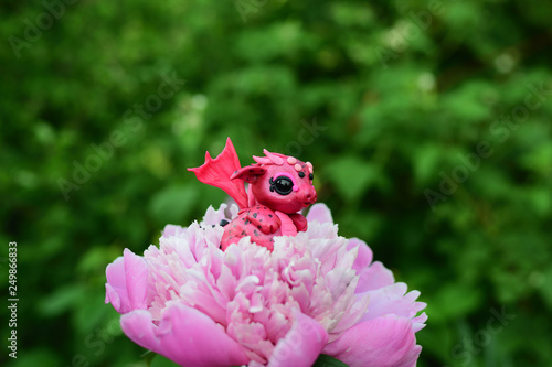 Red dragon toy on a flower