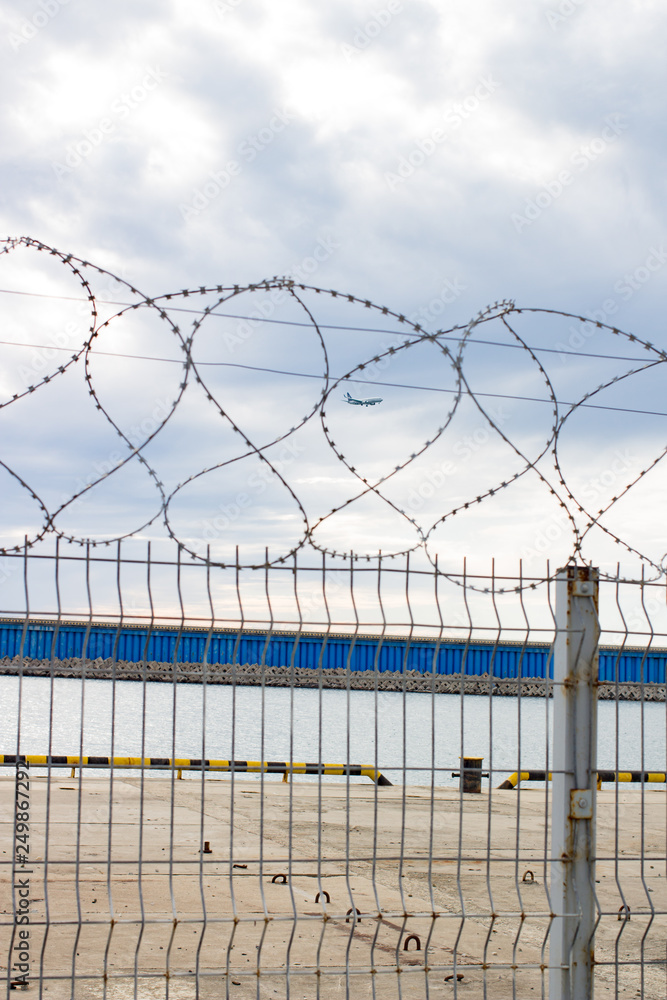 Fototapeta premium Barbed wire at the marina sea daytime