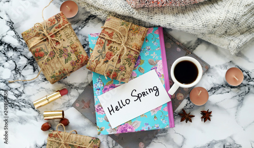 white Cup with coffee and gifts with Hello Spring text and glasses on marble table
