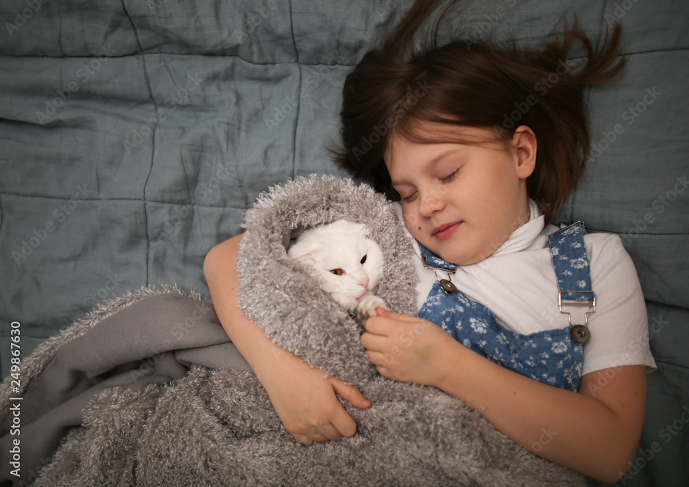 Cat and child comfortably sleep hugging on bed Cat and child comfortably sleep hugging on bed
