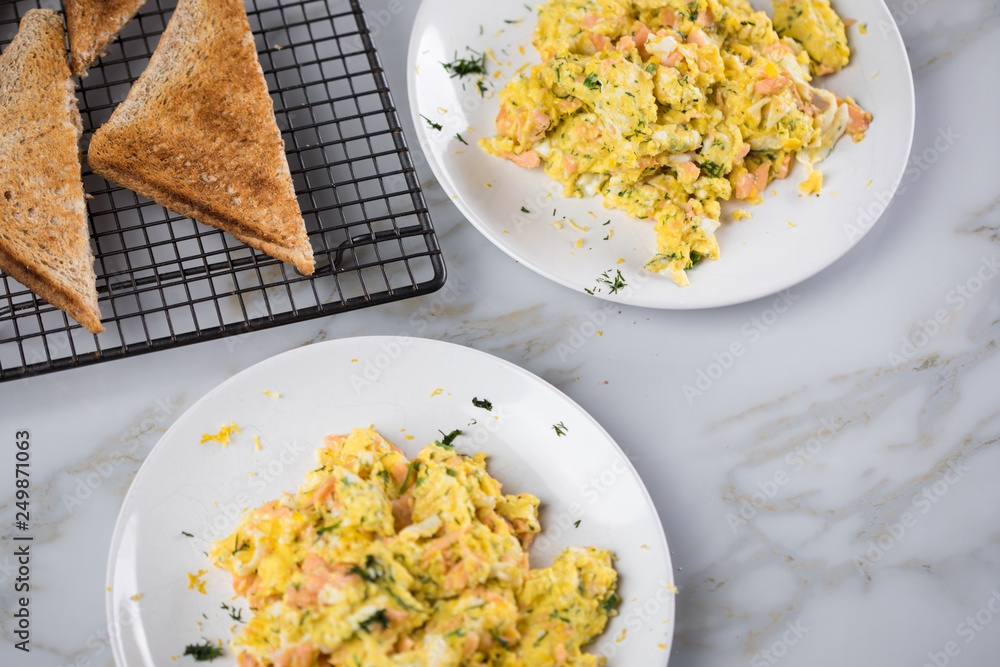 Räucherlachs Rührei mit Dill und Vollkorn Toast auf Marmor Hintergrund ...