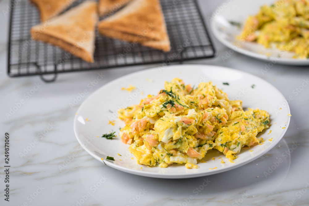 Räucherlachs Rührei mit Dill und Vollkorn Toast auf Marmor Hintergrund Räucherlachs Rührei mit Dill und Vollkorn Toast auf Marmor Hintergrund