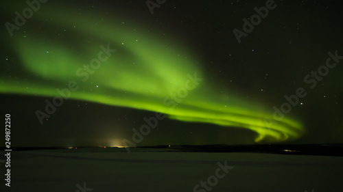 фотографія Northern light (aurora borealis) in the horizon above Ivalo from Saariselka in Finnish Lapland