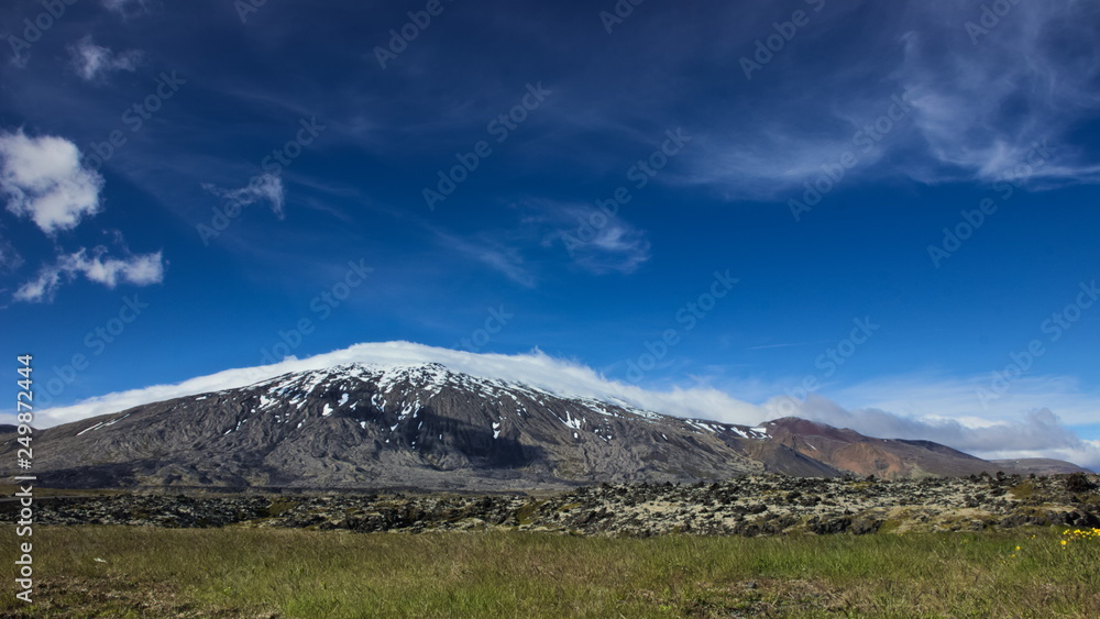 Clouds rolling over Snaefellsjokull glacier on a sunny day on Snaefellsnes peninsula in Western Iceland.