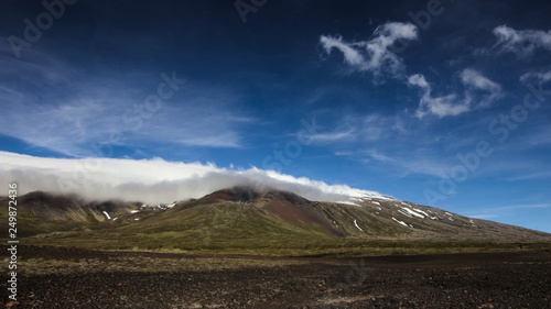 Clouds rolling over Snaefellsjokull glacier on a sunny day on Snaefellsnes peninsula in Western Iceland.